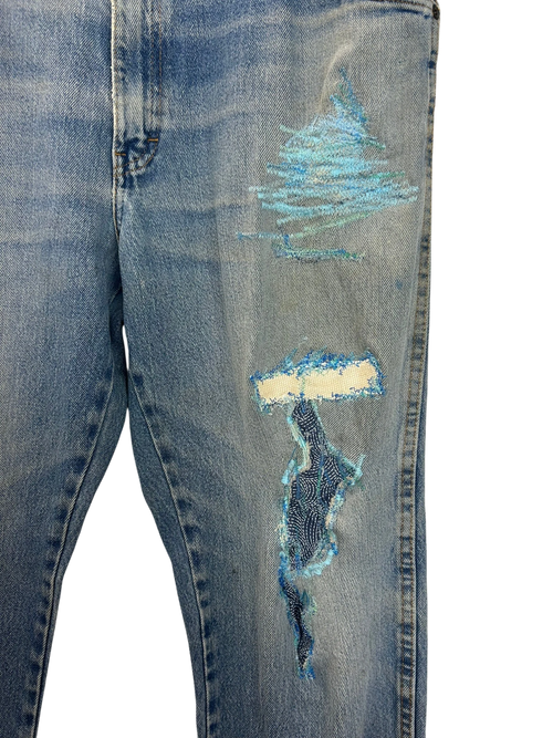 Lahad Vintage light wash denim jeans with distressed details and blue embroidered patches on the leg.