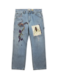 Lahad Vintage light-wash denim jeans with abstract rainbow embroidery and a fly patch. Custom art trousers.