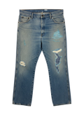 Lahad Vintage light wash denim jeans with distressed rips and blue embroidered patches on the legs.
