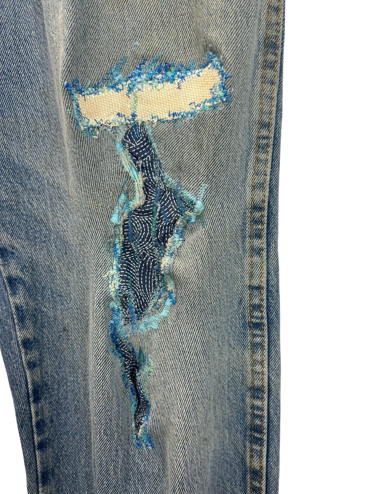 Lahad Vintage light wash denim jeans with distressed patches and blue stitching details.